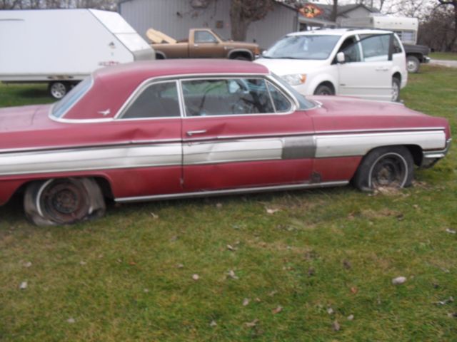 1962 burgundy Oldsmobile Starfire Coupe