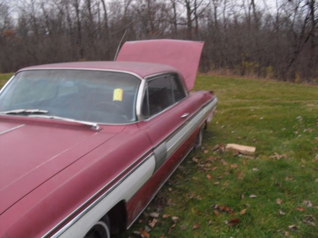 1962 burgundy Oldsmobile Starfire Coupe