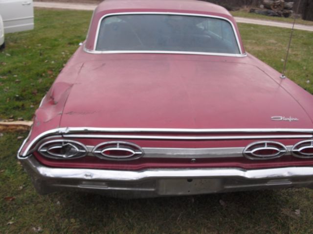 1962 burgundy Oldsmobile Starfire Coupe