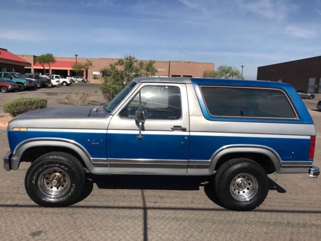 1985 blue and gray Ford Bronco 2door suv