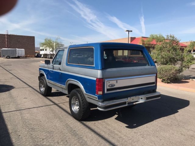 1985 blue and gray Ford Bronco 2door suv