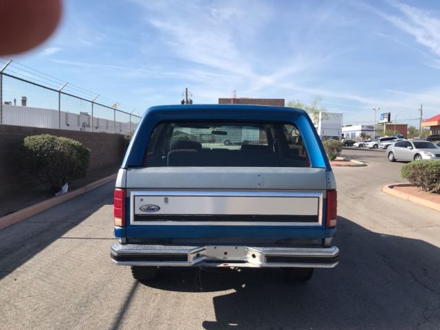 1985 blue and gray Ford Bronco 2door suv