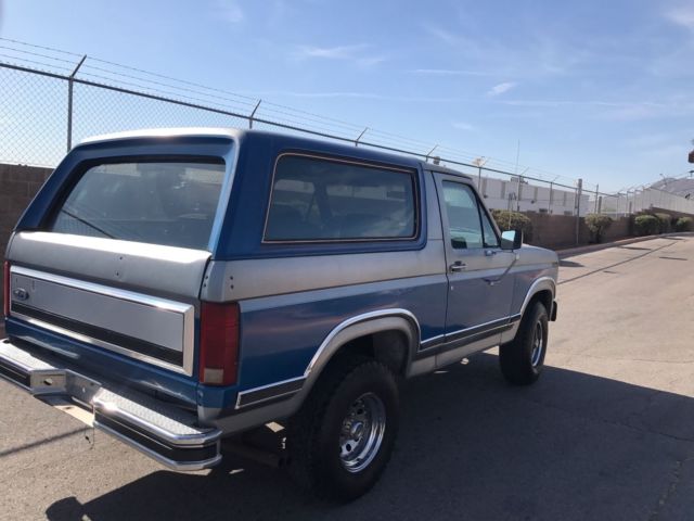 1985 blue and gray Ford Bronco 2door suv