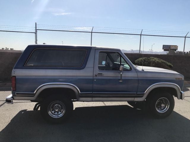 1985 blue and gray Ford Bronco 2door suv