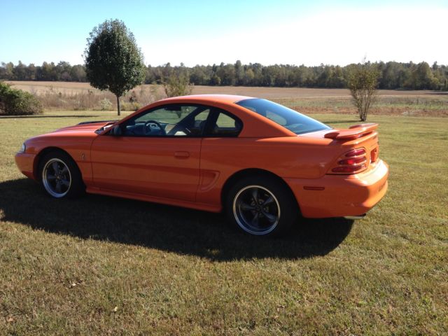 1994 orange Ford Mustang 2 door