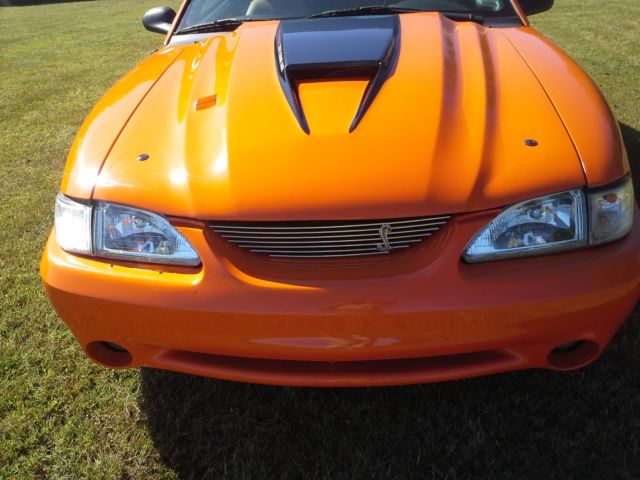 1994 orange Ford Mustang 2 door