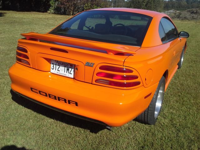 1994 orange Ford Mustang 2 door