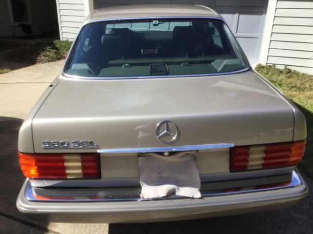 1987 gold Mercedes-Benz 500-Series SEDAN
