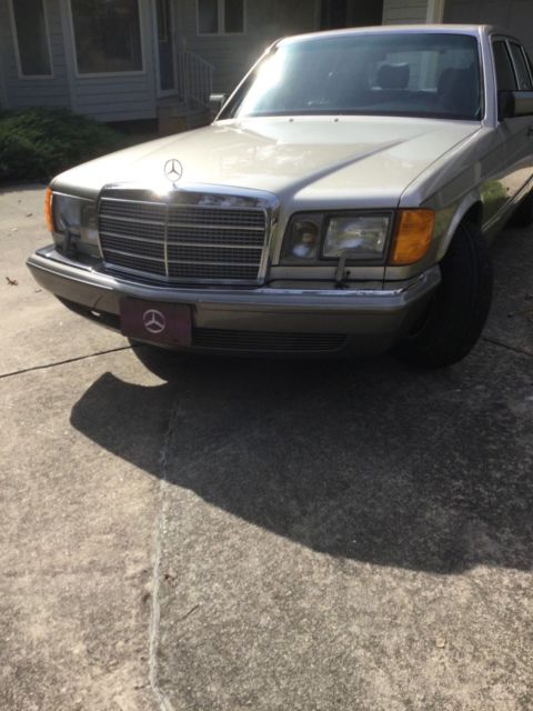1987 gold Mercedes-Benz 500-Series SEDAN