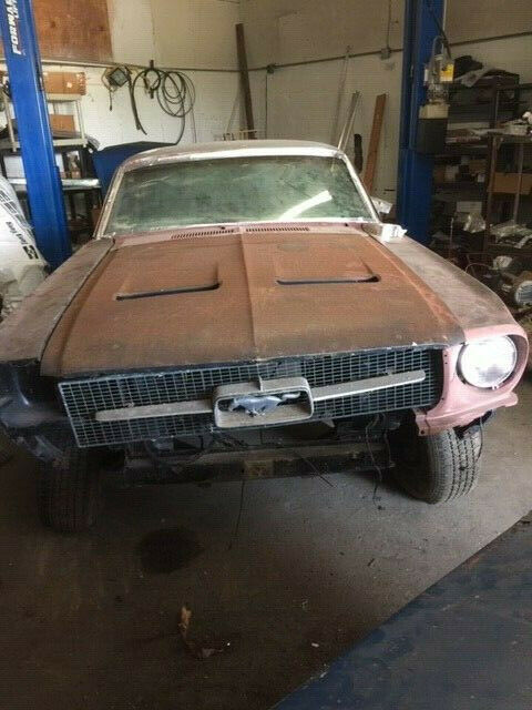 1968 primer red Ford Mustang Coupe