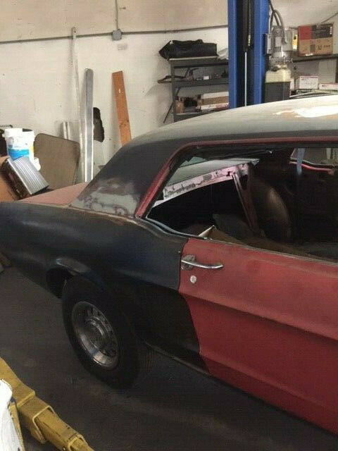 1968 primer red Ford Mustang Coupe